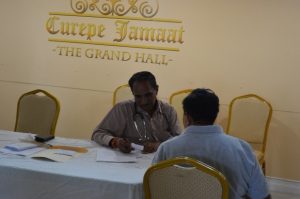NCRHA doctor interviews a patient before screening at the Curepe Jamaat.